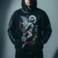 Unisex oversized black hoodie made from 350GSM heavyweight fleece. This vintage-style pullover features a striking graphic of a guardian angel or archangel with a sword, accented with red gothic text. The hoodie has a unique spray-paint effect along the seams, a soft brushed interior, and a relaxed, drop-shoulder fit, blending darkwear, angelic, and streetwear aesthetics.